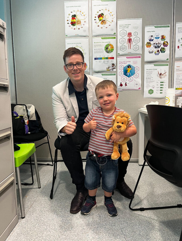 Aaron Brown from Health Assist with young Leo as he receives his insulin pump